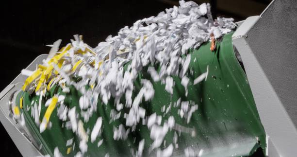 Shredded paper falling from paper shredder machine.