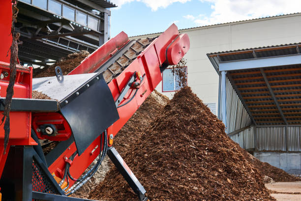 close-up conveyor of an industrial wood shredder producing wood chips from bark