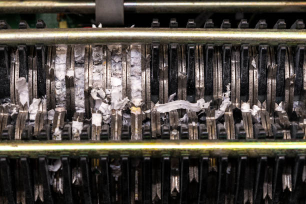 The inside of a paper shredder. The shredding mechanism is visible, and there are bits of paper in it. Closeup view.